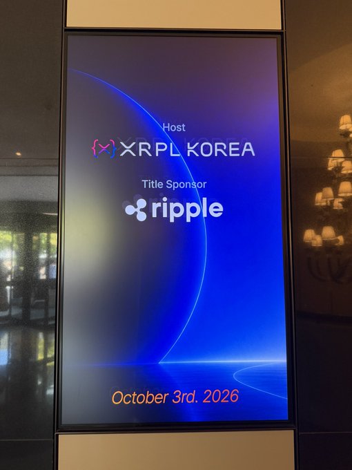 A digital display screen reads 'Host XRPL KOREA', 'Title Sponsor ripple', and 'October 3rd, 2026' against a blue background.