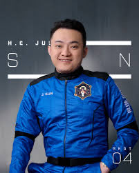 A figure in a blue tracksuit-style jacket with a crest has an exaggerated smiling face superimposed, against a gray background with the text 'JIU ZHEN' and '4' visible.