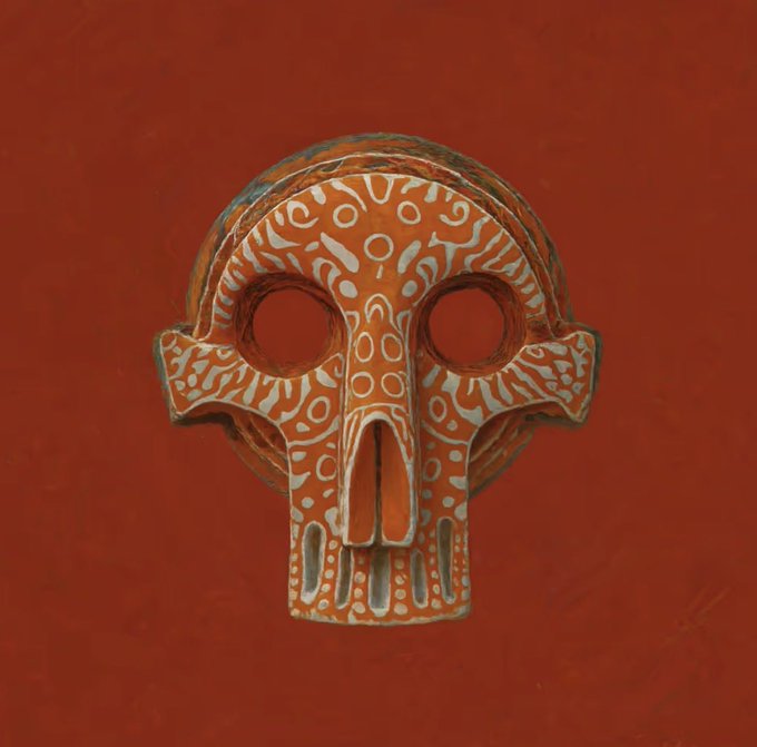 The image features an orange, ornate skull carved from wood or cardboard with intricate designs painted onto its surface. The skull appears to be a decorative piece of art rather than a functional one, as indicated by the presence of an ear on one side but no nose.