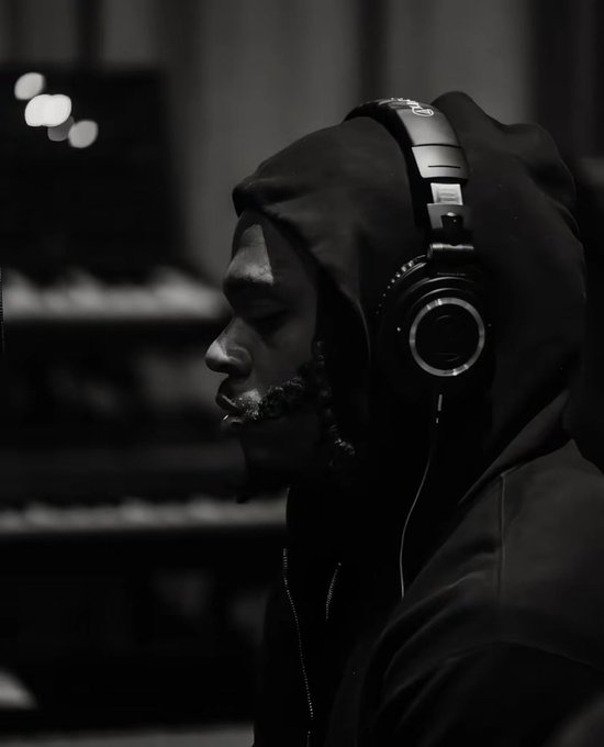 A black-and-white profile portrait shows a man with his eyes closed wearing a hoodie and over-ear headphones in a dimly lit setting.