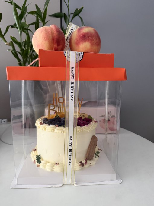 A birthday cake decorated with fresh blueberries and strawberries sits in a clear gift box tied with a "Happy Birthday" ribbon and topped with two peaches, branded with "Happy Birthday" and "Cake" text, perfectly complementing the celebratory message about reaching a milestone VIP status on Binance.