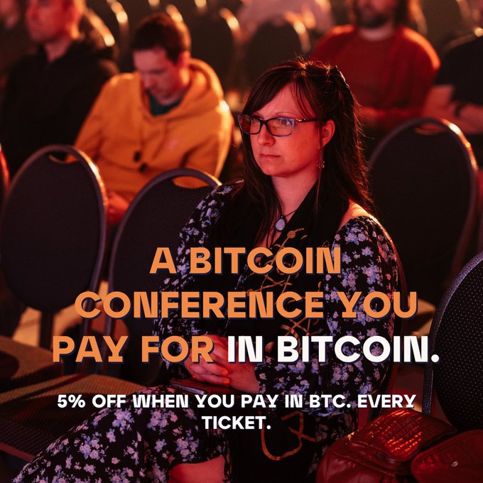 Promotional image for a Bitcoin conference featuring a woman with glasses, reading 'A BITCOIN CONFERENCE YOU PAY FOR IN BITCOIN. 5% OFF WHEN YOU PAY IN BTC. EVERY TICKET.'