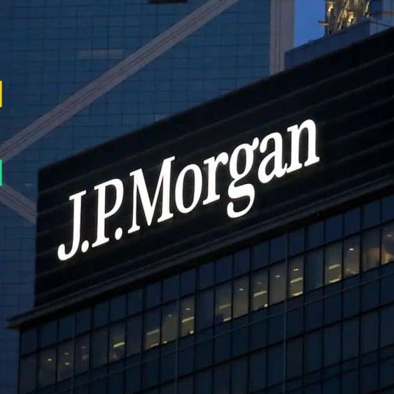 The illuminated "J.P. Morgan" sign atop a modern glass-facade building echoes the article's news of the banking giant deepening its blockchain footprint by extending its JPM Coin to Ethereum for around-the-clock USD transfers.