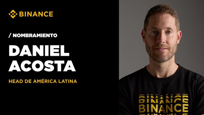 The image features a man wearing a black t-shirt with gold text that says "Daniel Acosta Head de América Latina". The background of the image is white, which makes the text stand out prominently. The caption below the photo reads "Binance fortalece su liderazgo en América Latina. Nos complace anunciar el nombramiento de Daniel Acosta como Head de América Latina, un paso que refuerza nuestro compromiso con el crecimiento, la innovación y la adopción cripto en la región". The image is related to the post because it features a man wearing a black t-shirt with gold text and the caption below the photo.