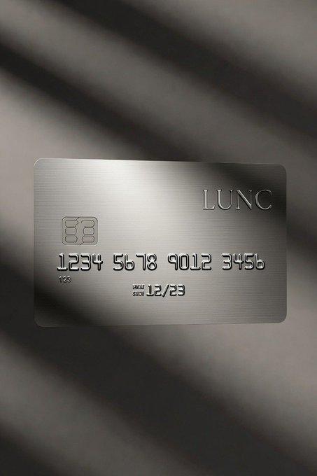 A sleek metallic LUNC (Terra Luna Classic) credit card rests on a draped fabric background, featuring an embossed chip and sample card number "1234 5678 9012 3456." The visual cleverly reinforces the post's vision of LUNC's trillion-unit supply enabling AI-driven micropayments, framing the token as a practical currency for future transaction-based economies.