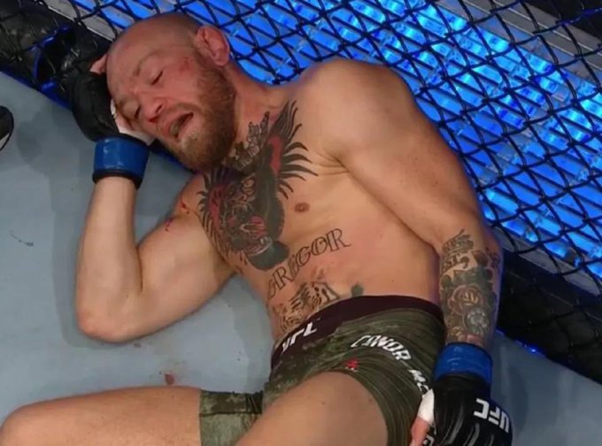 Conor McGregor is seen defeated on the mat after a fight, in a moment that humorously aligns with the post's theme of financial calculation losses. The image depicts "McGregor" tattooed across his stomach and the UFC logo visible on his shorts.