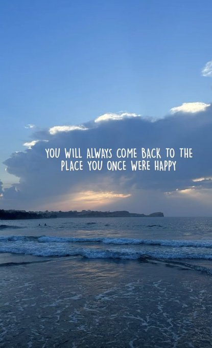 A scenic view of a beach with ocean waves at sunset, overlaid with the white text 'YOU WILL ALWAYS COME BACK TO THE PLACE YOU ONCE WERE HAPPY'.