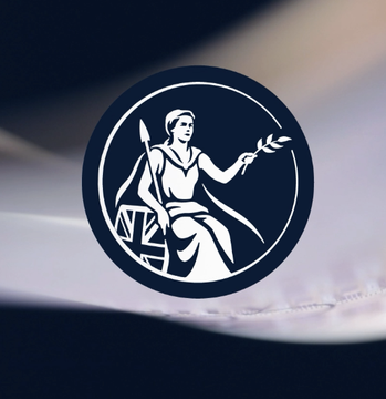 The image features a circular logo that includes a woman holding a sword, symbolizing strength and power. The background of the logo is black, which contrasts with the white elements within the design. The text "BANK OF ENGLAND SPOTLIGHTS CHAINLINK ORACLES Chainlink participated in the Bank of England's DLT Innovation Challenge." indicates that this logo represents a partnership between the Bank of England and Chainlink, who are collaborating on developing innovative solutions for financial transactions using blockchain technology.