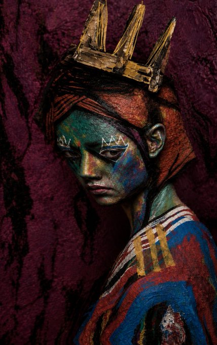 A textured painting of a melancholic figure with greenish skin wearing a golden crown and patterned clothing against a deep maroon background.