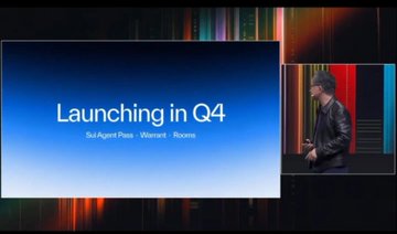 A man in a black leather jacket stands on stage next to a large screen displaying 'Launching in Q4' with bullet points for 'Sol Agent Pass', 'Waxset', and 'Rexos'.