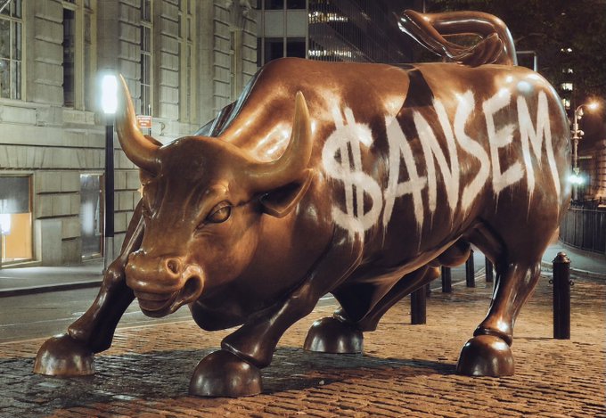 A bronze charging bull statue stands on a cobblestone street at night, its side spray-painted with "$ANSEM" in white lettering—evoking the iconic Charging Bull of Wall Street as a bullish symbol for the ANSEM token's anticipated rally.