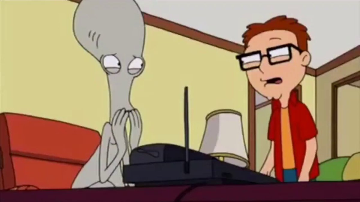The image features a cartoon scene with an alien character sitting at a desk, looking down while holding a remote control. A man wearing glasses stands next to the alien, who appears to be watching TV or using another electronic device. The caption reads "sol is like actually falling for sincere and don't see the neon red flags". This phrase suggests that the man might have fallen for the alien's charm or personality, despite its deceptive appearance.