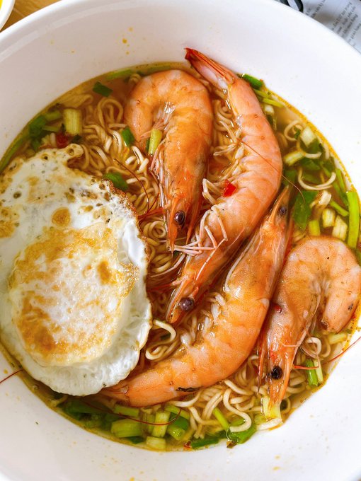 The image features a bowl of food with shrimp, noodles, and an egg. There are three shrimp visible in the dish along with some green vegetables. The photo appears to be taken from above, providing a close-up view of the meal. The post seems to be about a recipe or cooking instructions for making this particular dish.
