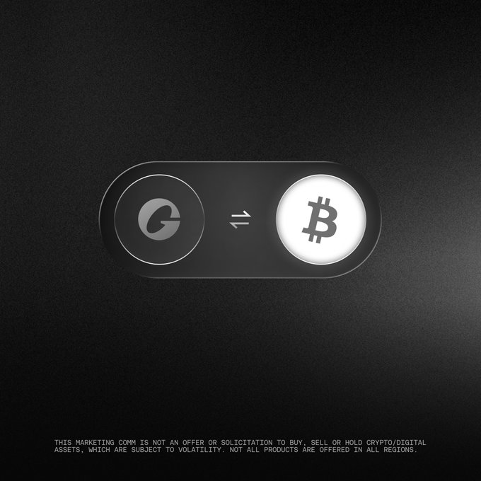 A sleek dark interface features a toggle switch between a "G" logo (USDG) and the Bitcoin "₿" symbol, with arrows indicating conversion. Below, a disclaimer reads: "This marketing comm is not an offer or solicitation to buy, sell or hold crypto/digital assets, which are subject to volatility. Not all products are offered in all regions." The image visually represents the choice between earning USDG rewards in Bitcoin or USDG itself.