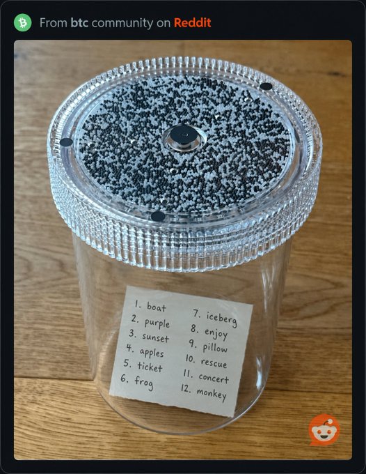 A Reddit post from the 'btc' community showing a clear container with a black-and-white speckled lid, containing a handwritten list of 12 words including 'boat', 'purple', 'sunset', and 'frog' (likely a hardware wallet seed phrase backup).