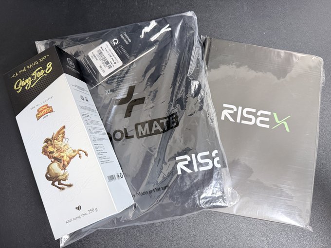 Packaged products including a box of 'Giang Lac 8' brand 'Ca Phe Rang Xay' (roasted coffee) and black packages labeled 'OL MATB' and 'RISEX' lie on a gray surface.