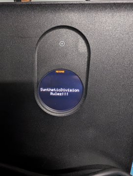 A close-up of a car dashboard infotainment screen displaying the text 'SyntheticDivision' and 'Robertll'.