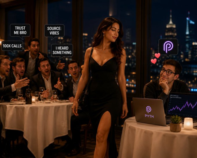 The image shows a woman wearing a black dress, walking past a man sitting at a table with his laptop open. The man appears to be looking up from his work as she walks by. In the background, there are other people present who seem to be engaged in conversation or focused on their own activities. A wine glass and a bottle can also be seen near some of them.