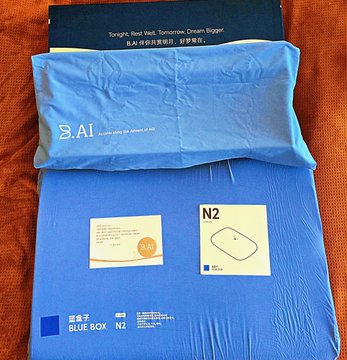 Blue packaged bedding items including a pillow and sheet set labeled 'A1' and 'BLUE BOX N2', with text reading 'Tonight, Rest Well. Tomorrow, Dream Bigger.'