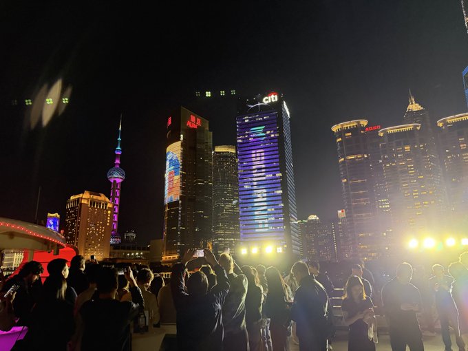 A crowd captures the illuminated Shanghai skyline at night, with the Oriental Pearl Tower and skyscrapers displaying "citi" and "AURORA" signage. The vibrant scene reflects the energy of the "Solana Accelerate China" event, highlighting the cryptocurrency conference's presence in Shanghai's bustling financial district.