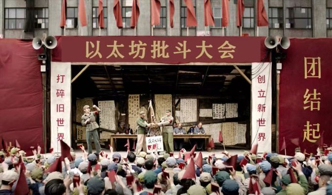 The image depicts a dramatic Chinese Cultural Revolution-era "以太坊批斗大会" (Ethereum Struggle Session) staged with actors and a crowd holding red flags, satirizing the crypto industry's criticism of Ethereum by likening a public denunciation of Ethereum leaders to a political purge rally. The banners read "打碎旧世界 创立新世界" (Smash the old world, create a new world) and "团结起来" (Unite), humorously framing the proposed ETH reforms—either liquidating to Musk or forming a corporate entity—as revolutionary measures demanded by the community.