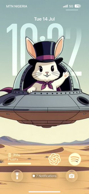 A smartphone lock screen showing the time 10:02 on Tuesday 14 July, with a wallpaper of a cute cartoon rabbit in a top hat waving from inside a UFO flying over a desert landscape, on an MTN Nigeria network.