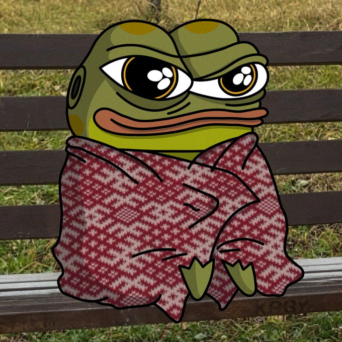 An illustrated cartoon frog with large eyes wrapped in a red and white checkered blanket, sitting on a park bench.
