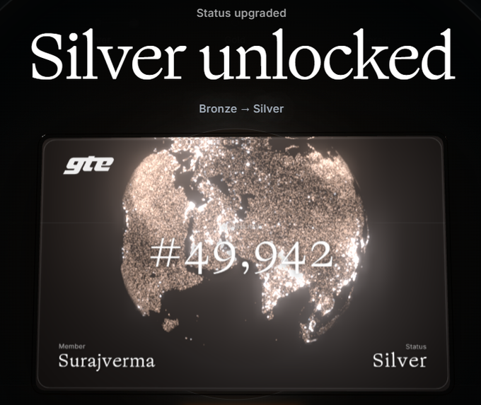 A digital status card reading 'Silver unlocked' for member Surajverma, upgrading from Bronze to Silver, featuring a glittering globe design and the number #49,942.
