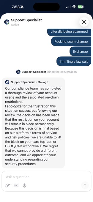 A screenshot of a Crypto.com Support Specialist chat where a frustrated user is told their account restrictions (blocking USDC/CAD withdrawals and card top-ups) will remain in place due to terms of service and risk policies, fueling the poster's complaint that "this scam exchange is going to ZERO $CRO TO ZERO."