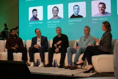 A panel discussion featuring speakers including Tal Ben-Shahar, John Conneely, Ryan Dennis, and Sabrina Drăgoi (as shown on the screen behind them) takes place on stage, with the context addressing institutional adoption challenges in crypto.

**Closing reflection:** Three years ago, accepting that onboarding speed mattered more than perfect due diligence felt like heresy in institutional finance. Now, the same people who said "move fast and break things" are learning that, onchain, the things that break are the things you didn't know were load-bearing. The panelists pictured likely represent the operational, academic, and entrepreneurial perspectives needed to bridge that slowness.