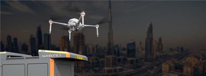 The image shows a cityscape with multiple buildings in various heights, including one that resembles the Burj Khalifa. An airplane-like drone flies above the city, possibly capturing aerial photographs or surveying infrastructure. The image also contains text elements such as "Onnd" and "$ONDS calls out May orders topping $30m." The city and the drone appear to be connected through this aerial perspective.