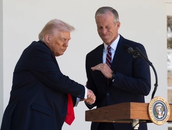 President Trump shakes hands with Senate Majority Leader John Thane at a podium bearing the Presidential Seal, accompanying a breaking announcement that Thune confirmed the Crypto Clarity Act will receive a Senate vote this week on market structure legislation.