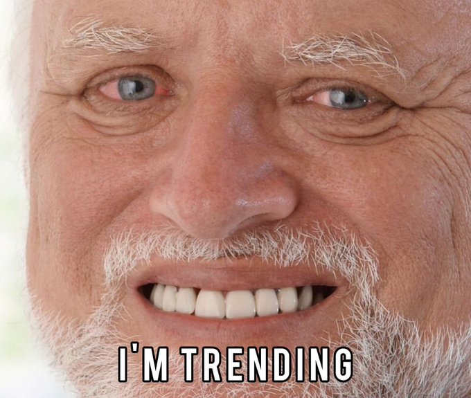 A close-up photo of an older man with a white beard smiling widely, with the text "I'M TRENDING" overlaid at the bottom.