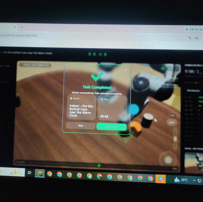 A laptop screen displays a "Task Completed" notification from axisrobotics.com/actor for "Task #1" titled "Indoor - Put the Eyebird Cup near the Alarm Clock," completed in 00:48 with a "Mission accomplished. Data uploaded successfully." message, reflecting the user's successful completion of today's Axis Robotics tasks before going to bed.