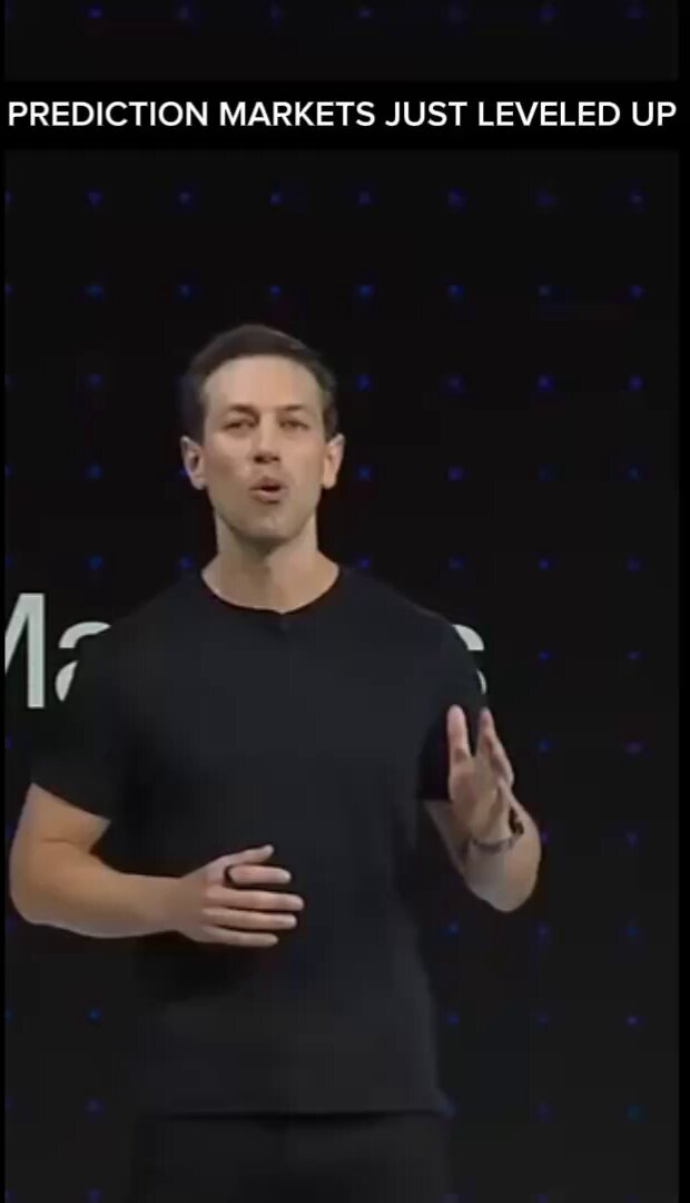 The image features a man standing in front of a black background, giving him an important role as he speaks into a microphone or a large screen. The text "Prediction Markets Just Leveled Up" is displayed above his head, indicating that this event has recently taken place and it's now available for viewing on the app store. The post also mentions that the app is designed to provide live data and faster markets, which could be related to the man speaking about a new technology or innovation in the financial industry.