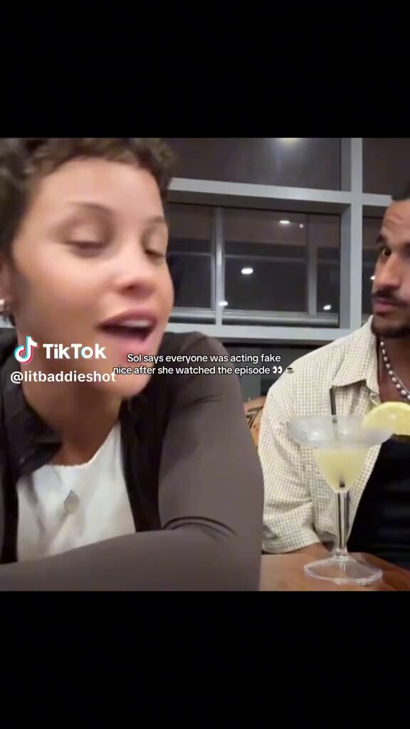 The image shows a woman sitting at a table with a glass of lemonade, while another person sits across from her. The woman appears to be talking or laughing, possibly sharing a funny story or joke with the other person. The caption "Sol was live on Gabe TikTok and she has alot to say SOLCIETY come over here" suggests that the woman might have been discussing a recent event or experience involving Sol, another character from their conversation.