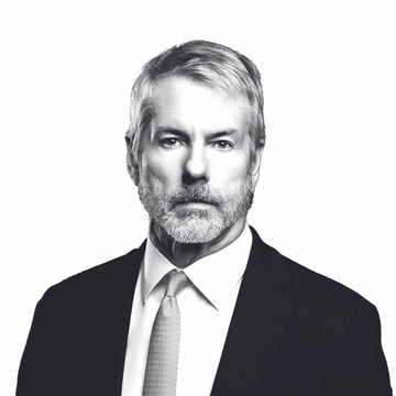 A black-and-white formal portrait shows a distinguished gray-haired man in a dark suit and tie, set against a plain white background. The image conveys a serious, authoritative tone fitting the breaking news headline about Bitcoin's drop below $62,000 following Strateji Co.'s reported divestiture.