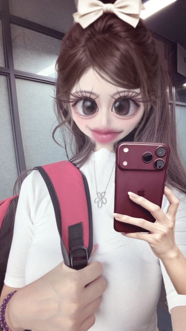 A selfie of a person with a digitally altered, cartoonish face filter showing exaggerated large eyes and a small mouth, wearing a beige bow and taking the photo with a red iPhone.