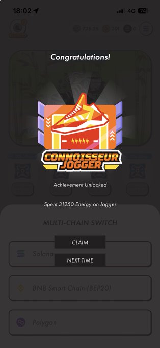 The image shows a phone screen displaying a congratulatory message for an achievement, likely related to cryptocurrency trading or gaming. The text on the screen reads "Congratulations! You have achieved something great!" This could be a milestone reached in a game or trading activity, such as winning a match or successfully completing a challenging level. 

The image also includes some text that says "Spontaneous energy transfer", which might be related to the gaming experience or cryptocurrency world. The screen displays various icons and logos associated with the achievement, including a pair of shoes, a sports ball, and a box.