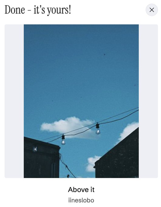 A photo titled 'Above it' by iineslobo showing string lights hanging against a blue sky with clouds, framed by rooftops, displayed on an interface reading 'Done - it's yours!'