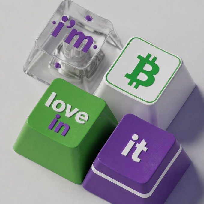 3D rendered graphic featuring keyboard keys spelling 'love in it' alongside a transparent key reading 'i'm.' and a white key displaying the Bitcoin logo.