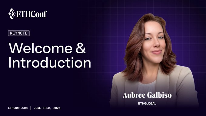 The image features a woman with brown hair wearing a white blazer, smiling for the camera as she appears to be introducing herself at an event. The background of the image is purple, which contrasts with her attire. The text "Welcome & Introduction" is displayed in black letters above and below the woman's head, indicating that this is part of a presentation or speech. The post also mentions that the main stage begins at 10:00am on June 8th.