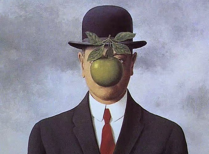 The image features a man dressed in a suit, with an apple placed over his face as if he has been transformed into a surreal painting. The man's head is hidden behind the apple, creating an intriguing and unexpected scene. The background of the image is gray, which further emphasizes the surreal nature of the artwork. The caption below the image reads "Launching Soon: Something surreal is coming. The face is hidden. The apple is green. The coin is real. $SOM #Solana Follow for CA drop #SonOfMan #MemeCoin #SonOfMan".