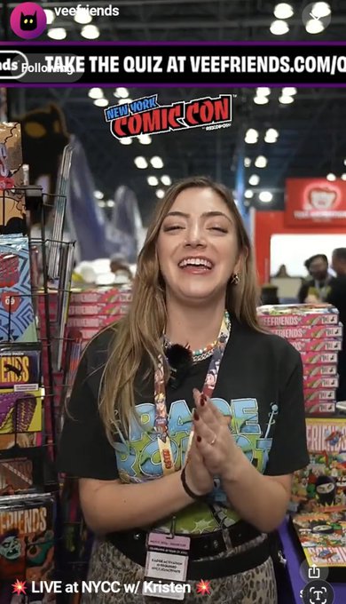 A woman at the New York Comic Con being interviewed at the Veefriends booth, with on-screen text reading "TAKE THE QUIZ AT VEEFRIENDS.COM/" and "LIVE at NYCC w/ Kristen".