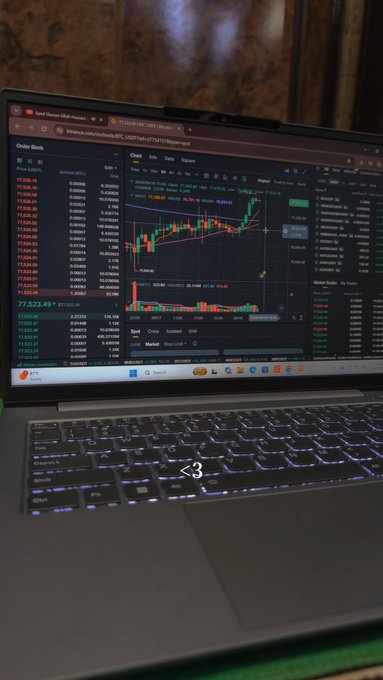 A laptop displaying a TradingView chart of BTC/USDT on Binance, sitting on a desk with a backlit keyboard.