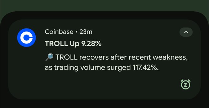 A Coinbase push notification from 23 minutes ago reports that TROLL is up 9.28%, recovering after recent weakness as trading volume surged 117.42%—matching the post's excitement over the 117% volume spike fueling TROLL's momentum toward potentially flipping DOGE.
