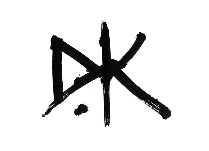 A bold black brushstroke painted symbol on white background resembling a stylized 'DK' or crossing character.