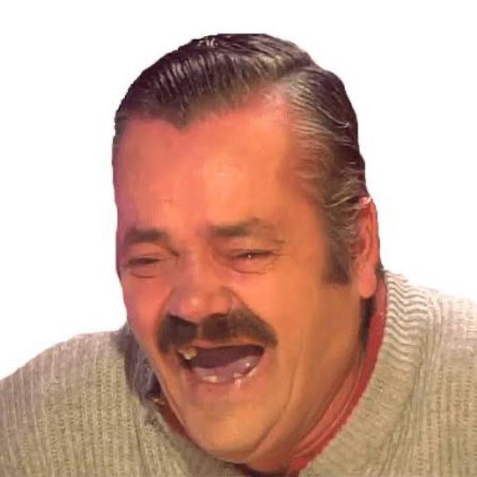 A close-up of an older man with slicked-back hair and a mustache laughing heartily, wearing a beige knit sweater with a red collar against a white background.