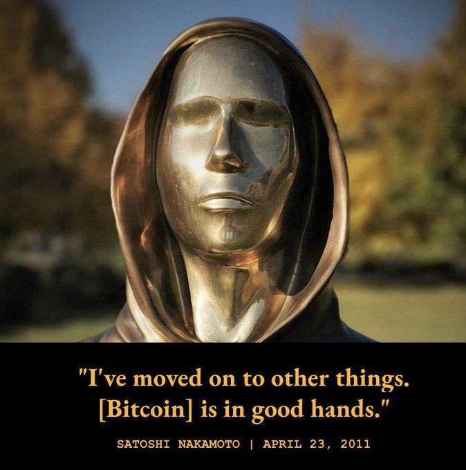 A bronze sculpture of a hooded figure with the quote 'I've moved on to other things. [Bitcoin] is in good hands.' attributed to Satoshi Nakamoto, April 23, 2011.