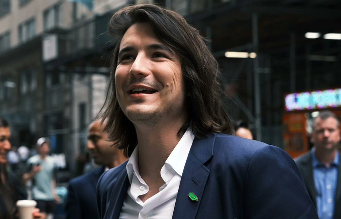 A smiling man with long dark hair, wearing a navy blazer and white shirt with a green leaf pin, stands on a city street.

The image shows a man outdoors in an urban setting, which doesn't directly relate to the accompanying post about Robinhood launching its Ethereum L2 blockchain called Robinhood Chain.